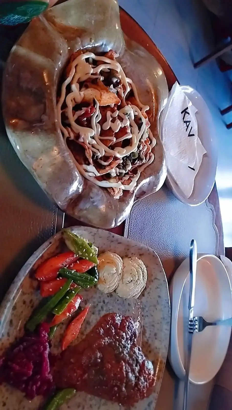 Plated KAV dish featuring a roasted beet, grilled vegetables and a carved meat portion with detailed patterns on white plates