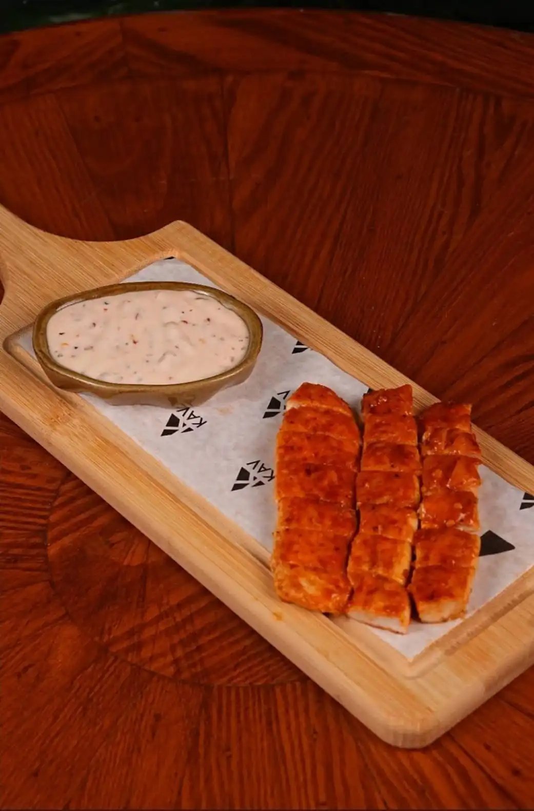 Sliced pepperoni served on a wooden board with white dip — KAV signature